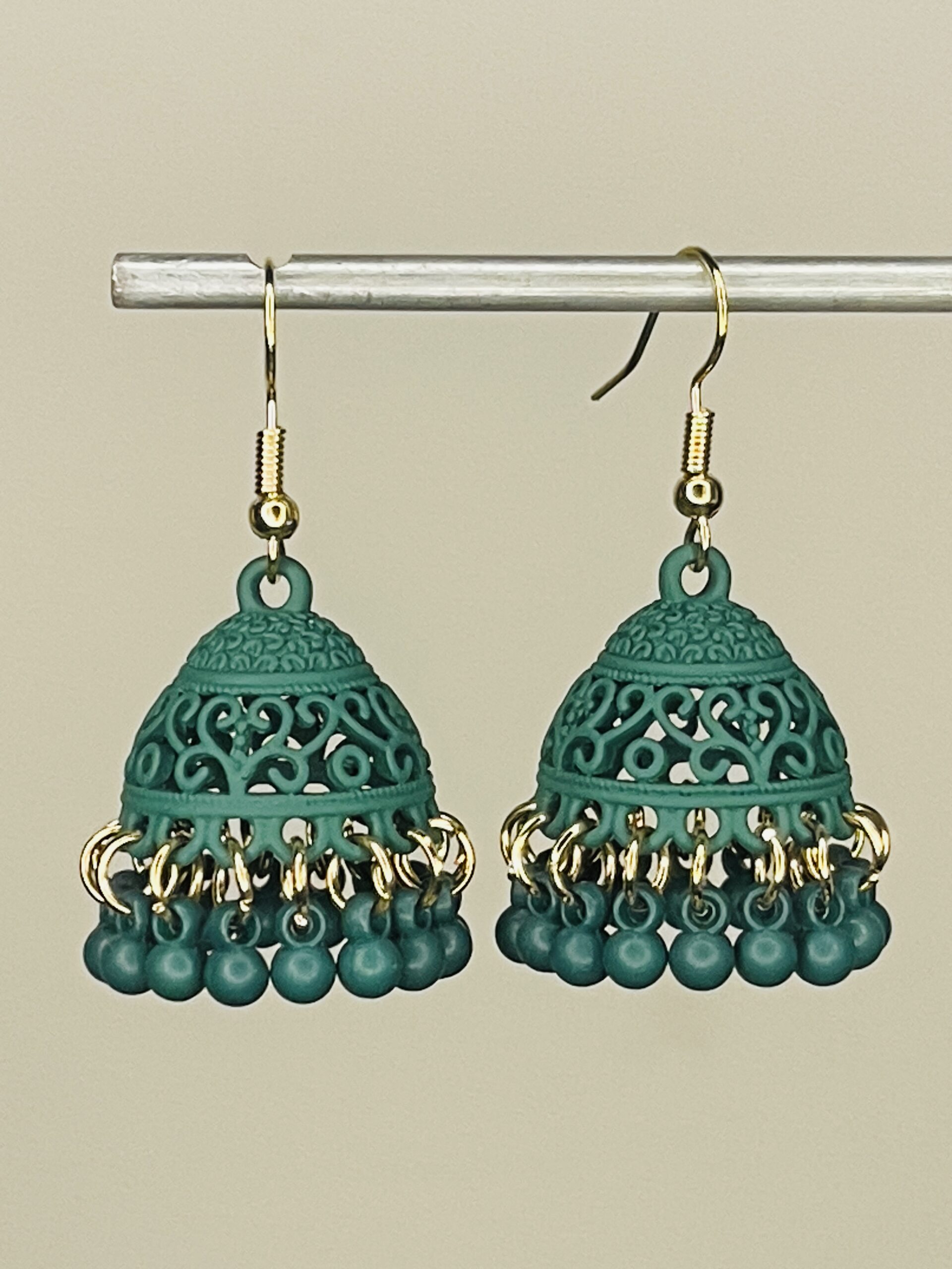 Pair of handcrafted Forest Green jhumka earrings with intricate floral design and dangling pink beads, featuring golden hooks and no golden bead detailing.