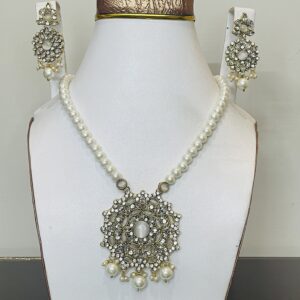Authentic real Kundan necklace set with pearl strand, handcrafted round pendant, and matching earrings displayed on a jewelry stand.