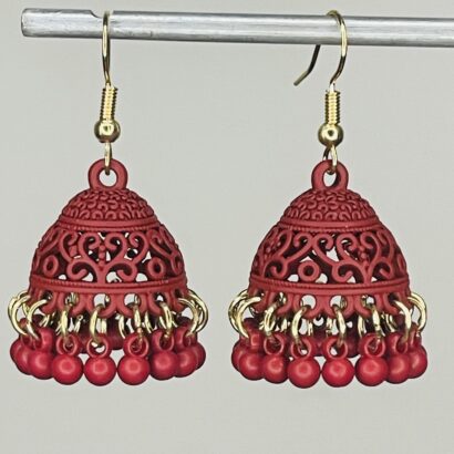 Pair of handcrafted light maroon jhumka earrings with intricate floral design and dangling pink beads, featuring golden hooks and no golden bead detailing.