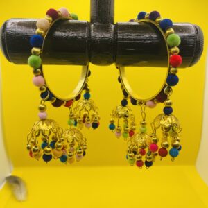 "Golden bangles decorated with colorful pom-poms and delicate dangling charms, traditional ethnic jewelry for weddings, mehndi, and festive celebrations."