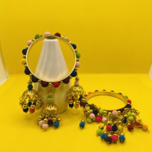 Golden bangles decorated with colorful pom-poms and delicate dangling charms, traditional ethnic jewelry for weddings, mehndi, and festive celebrations."