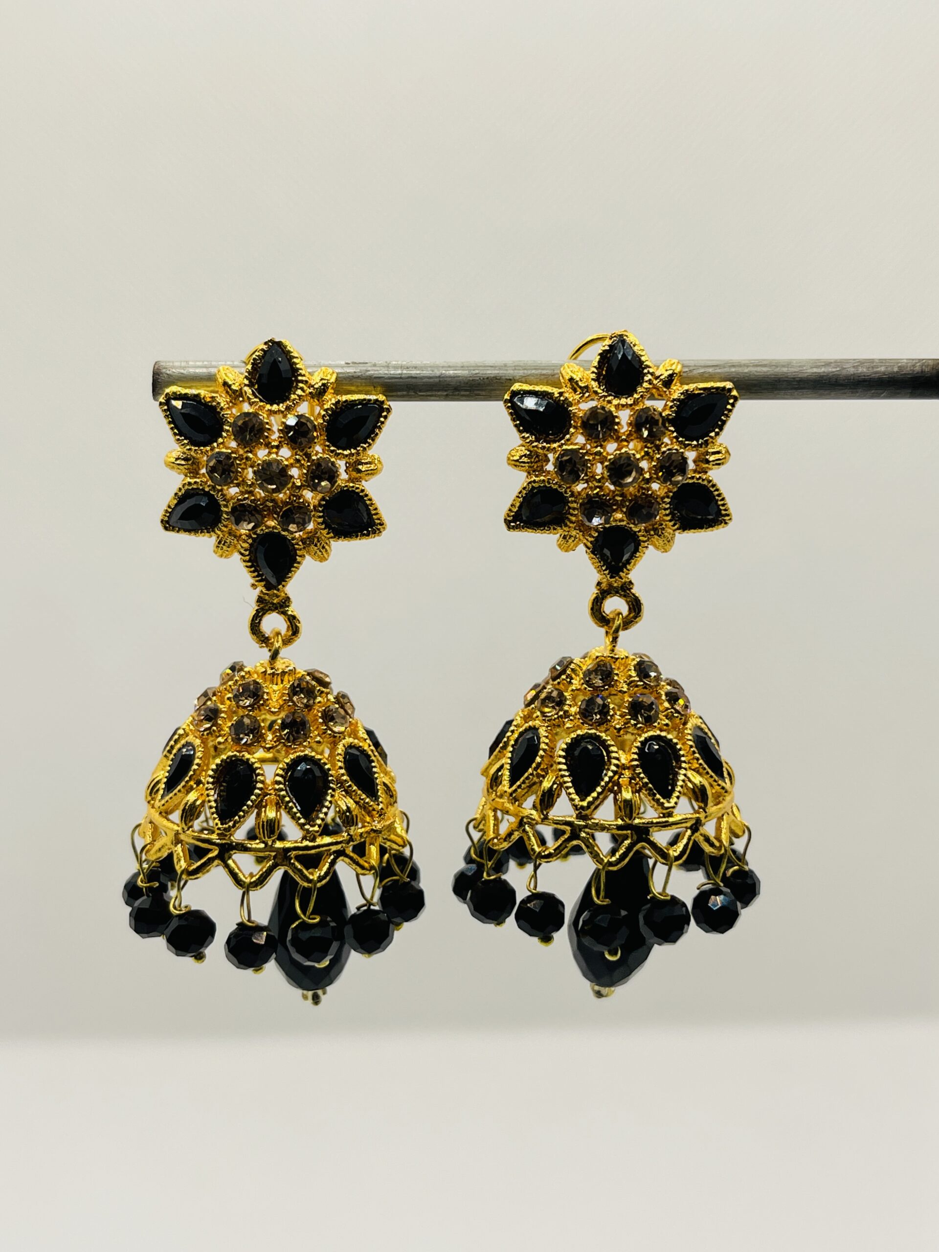 Elegant black and gold jhumka earrings with intricate floral design, perfect for weddings, parties, and festive occasions.